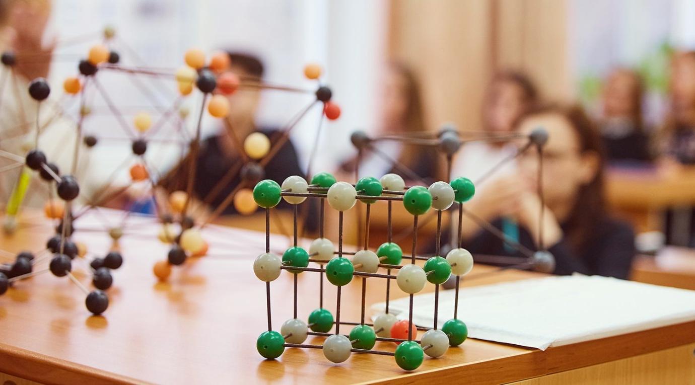 Ball and stick models representing molecular structures sit on a table